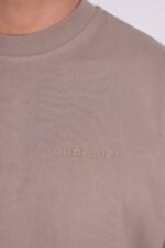 Maschinenwäsche kalt mit ähnlichen Farben, um die Taupe-Farbe zu erhalten. Waschen Sie das Kleidungsstück auf links, um das Ton-in-Ton-Logo auf der Brust zu schonen. Zum Trocknen flach hinlegen, um die ursprüngliche, eckige Form zu erhalten. Bei niedriger Temperatur bügeln und direkten Kontakt mit dem Logo vermeiden.